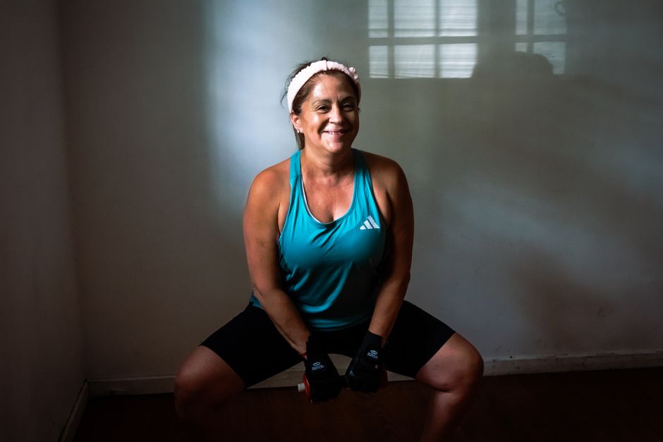 Healthy woman working out indoors with dumbbells, promoting fitness and strength.