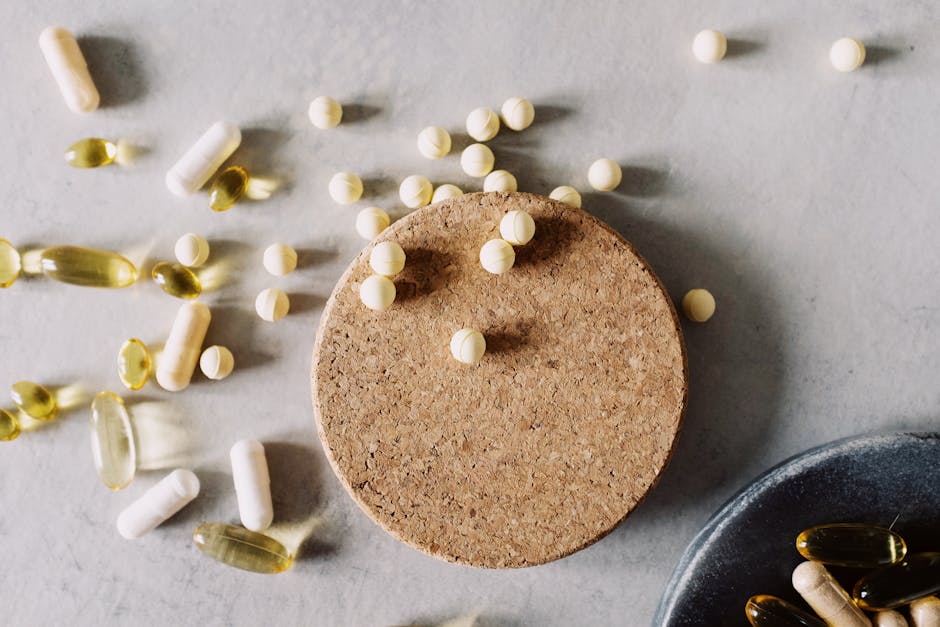 Assorted pills and capsules on a marble surface, highlighting healthcare and medicine.