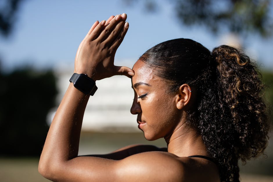Side view of a woman meditating outdoors with closed eyes, embracing relaxation and wellness.