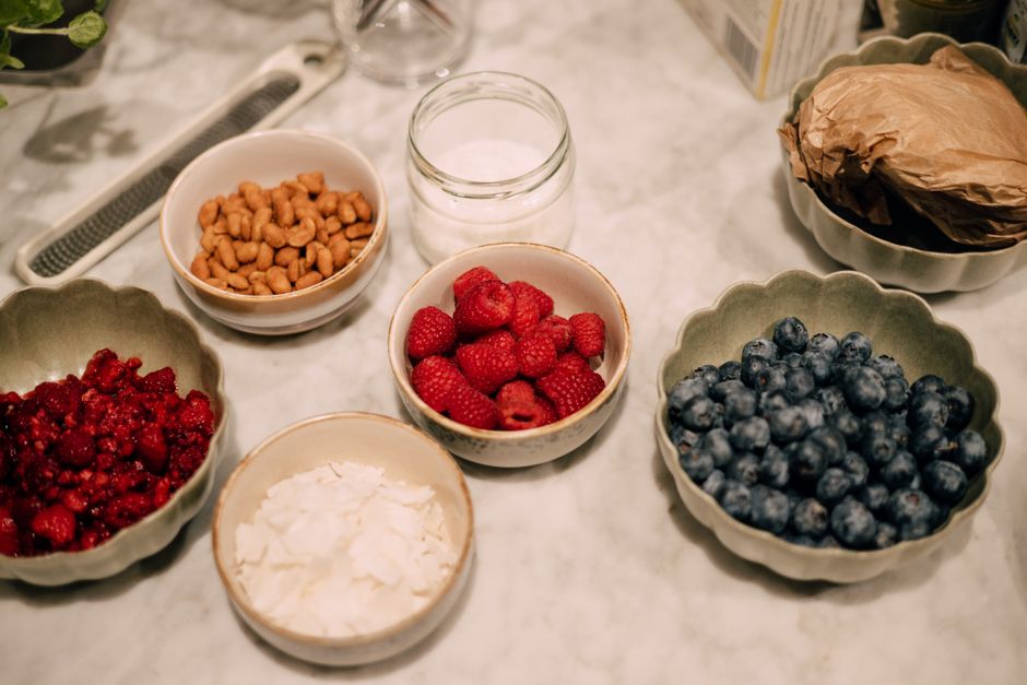 A variety of fresh berries, nuts, and ingredients in bowls perfect for breakfast or food photography.