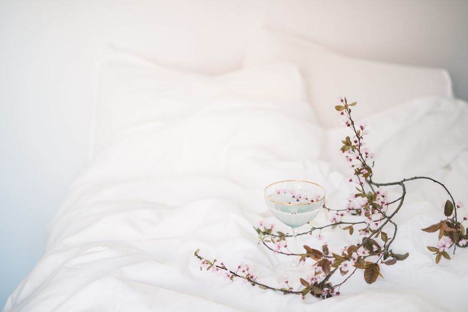 Delicate spring blossoms on a white blanket with soft pastel tones, creating a serene atmosphere.