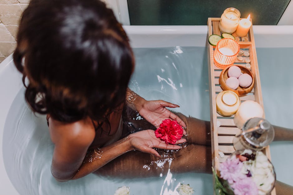 A woman enjoying a spa-like bath with floating candles and flowers, creating a peaceful atmosphere.