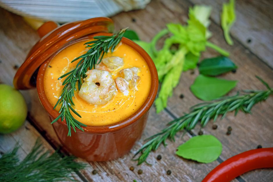 Delicious shrimp bisque garnished with herbs, perfect for a cosy meal.