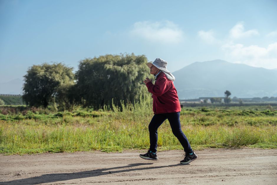 Woman jogging along a quiet country road in spring